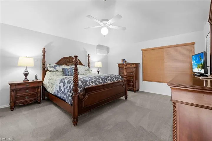 Carpeted bedroom featuring ceiling fan