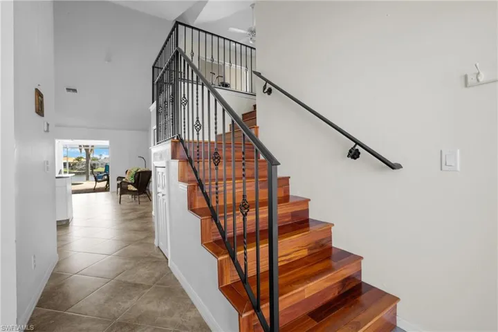 Staircase with a high ceiling and tile patterned floors