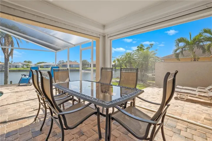 View of patio featuring a lanai and a water view