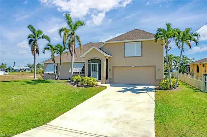 View of front of property with a garage and a front lawn