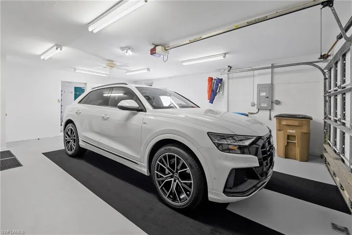 Garage featuring ceiling fan, a garage door opener, and electric panel