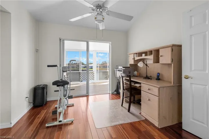 Office space with dark hardwood / wood-style floors and ceiling fan