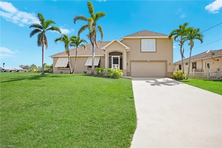 View of front of house featuring a front yard and a garage