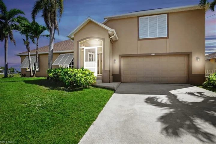 View of front of house with a yard and a garage
