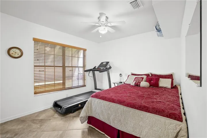 Bedroom with light tile patterned floors and ceiling fan