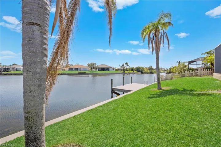 Dock area featuring a lawn and a water view