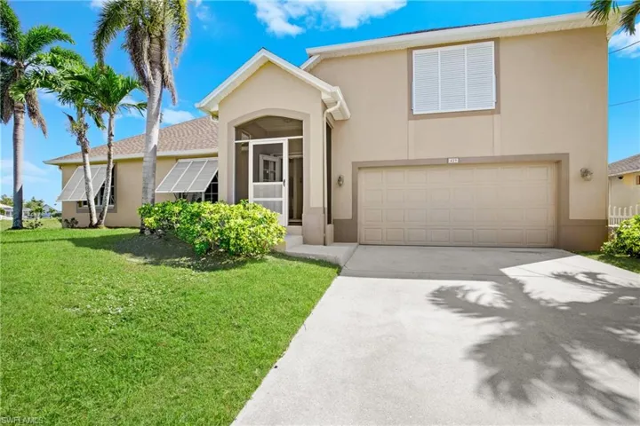 View of front of house featuring a garage and a front lawn