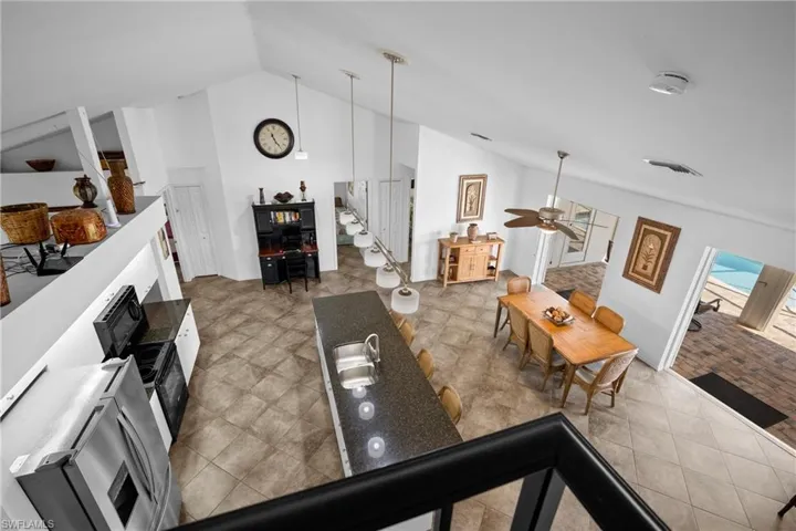 Living room featuring ceiling fan, wood-type flooring, and lofted ceiling