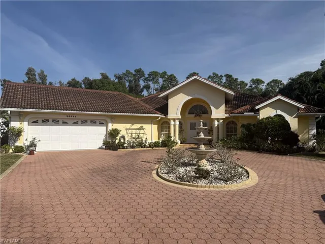 Mediterranean / spanish-style home featuring curved driveway, stucco siding, an attached garage, and a tile roof