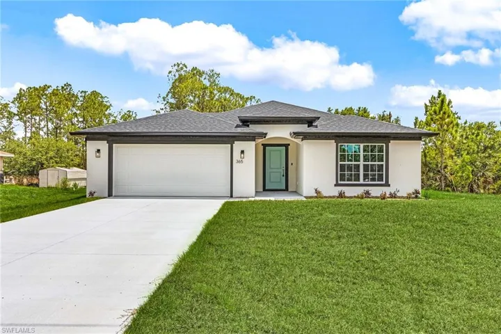 Prairie-style house with stucco siding, driveway, an attached garage, a front lawn, and a shingled roof