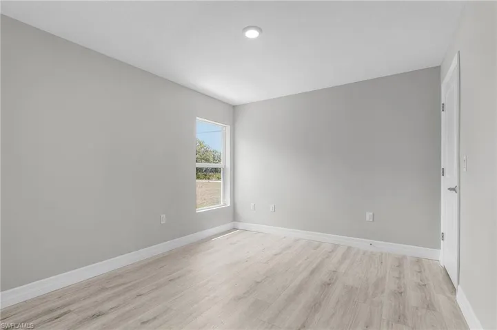 Empty room with light wood-style flooring and baseboards
