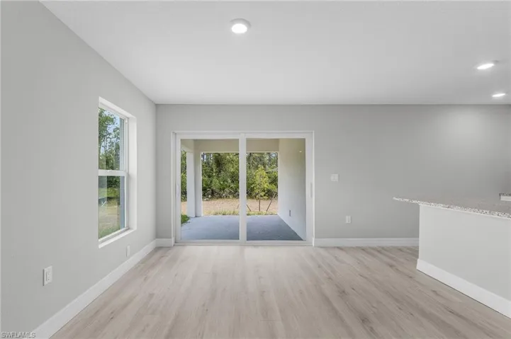 Unfurnished room featuring light wood-style floors, baseboards, and recessed lighting