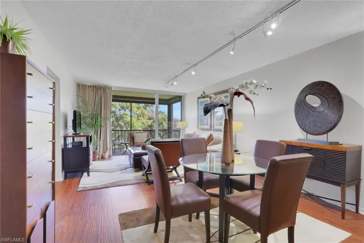 Dining room featuring a textured ceiling, wood finished floors, and track lighting