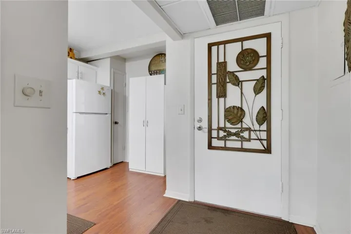 Kitchen with freestanding refrigerator, white cabinetry, and light wood finished floors