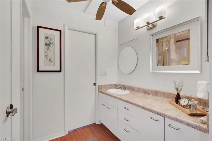 Bathroom with vanity, light wood finished floors, and a ceiling fan
