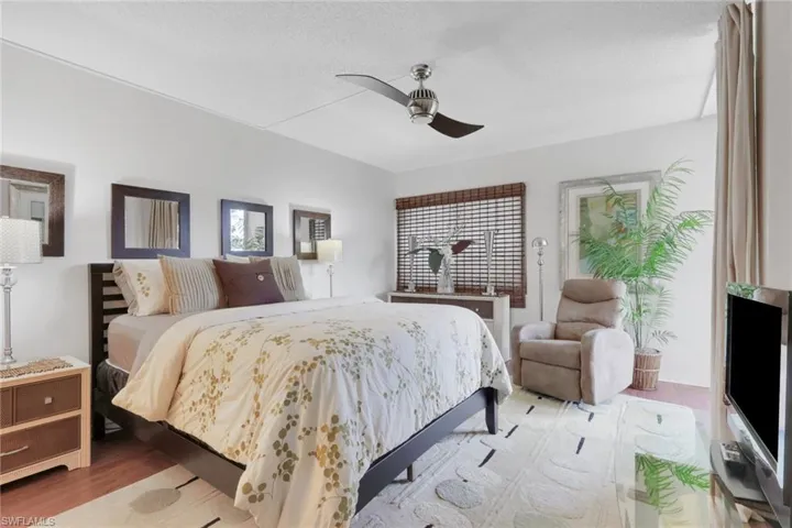 Bedroom featuring ceiling fan, a textured ceiling, and wood finished floors