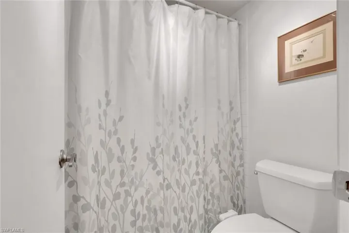 Full bath featuring toilet and a shower with curtain