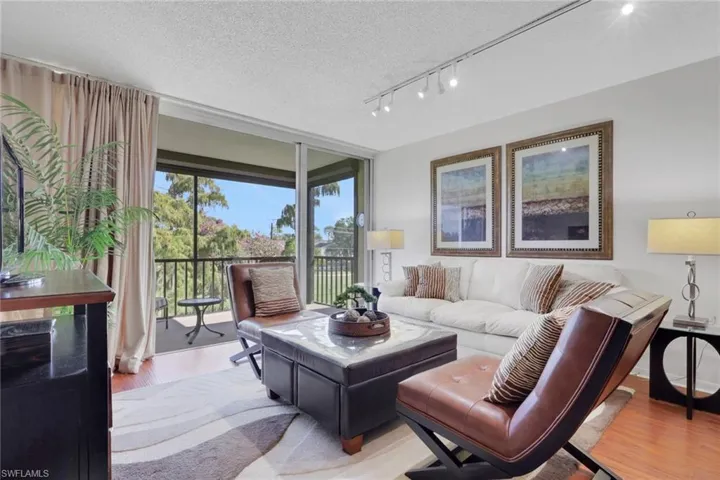 Living area with wood finished floors, a textured ceiling, and expansive windows