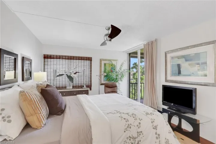 Bedroom featuring access to outside, a ceiling fan, and wood finished floors