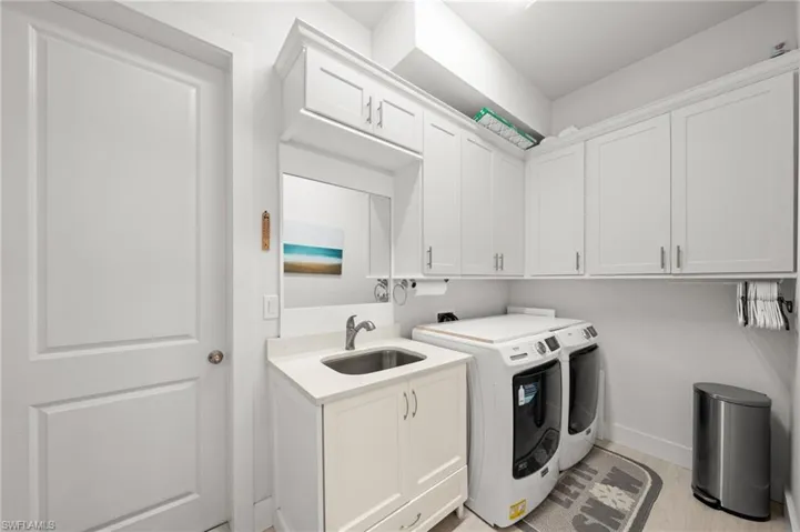 Washroom featuring cabinet space, separate washer and dryer, and light wood-style flooring