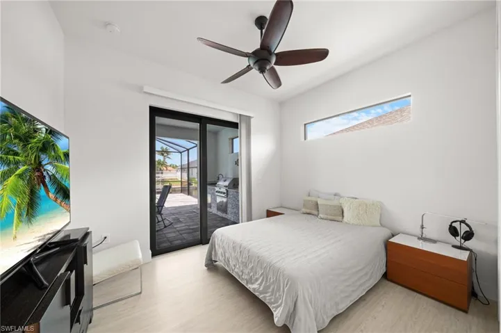 Bedroom with light wood-style flooring, access to exterior, and ceiling fan