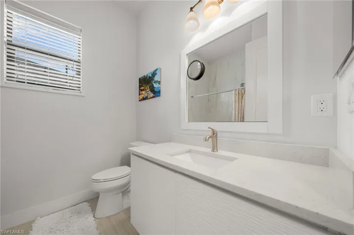 Bathroom featuring vanity, curtained shower, and wood finished floors
