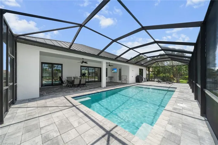 Swimming pool featuring a ceiling fan, a patio, and a lanai
