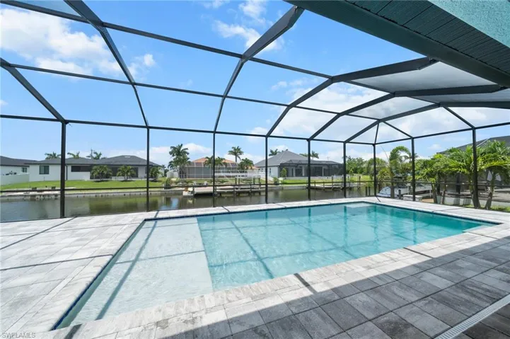 Outdoor pool featuring a water view, a residential view, and a patio area