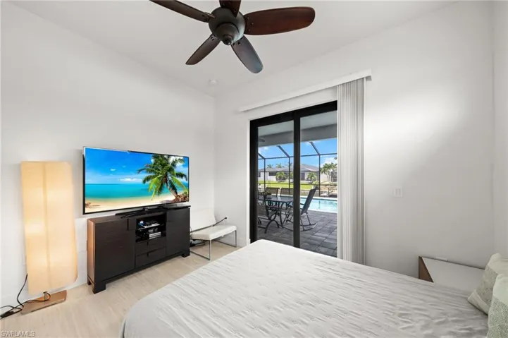 Bedroom with access to exterior, a ceiling fan, and light wood finished floors