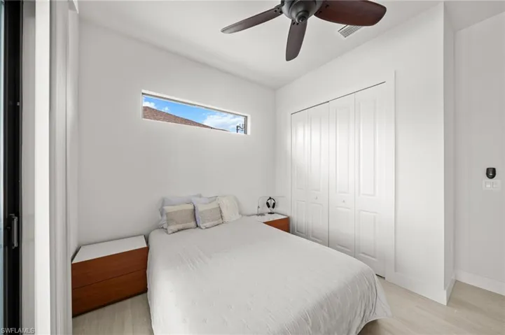 Bedroom with light wood-style floors, a closet, and a ceiling fan