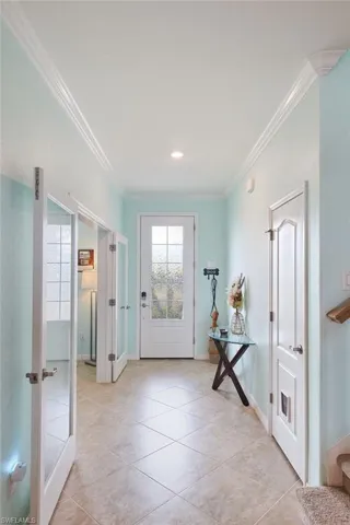 Doorway featuring ornamental molding, french doors, and light tile patterned flooring