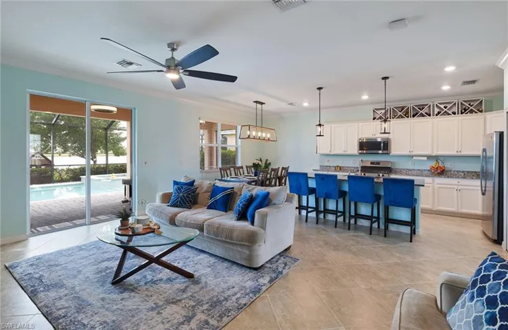 Living room with crown molding, ceiling fan, and light tile patterned floors