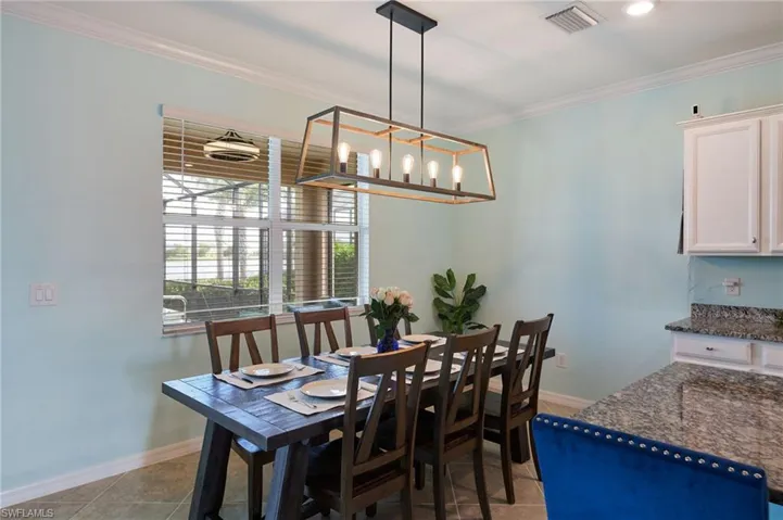Dining room featuring light tile patterned floors and ornamental molding
