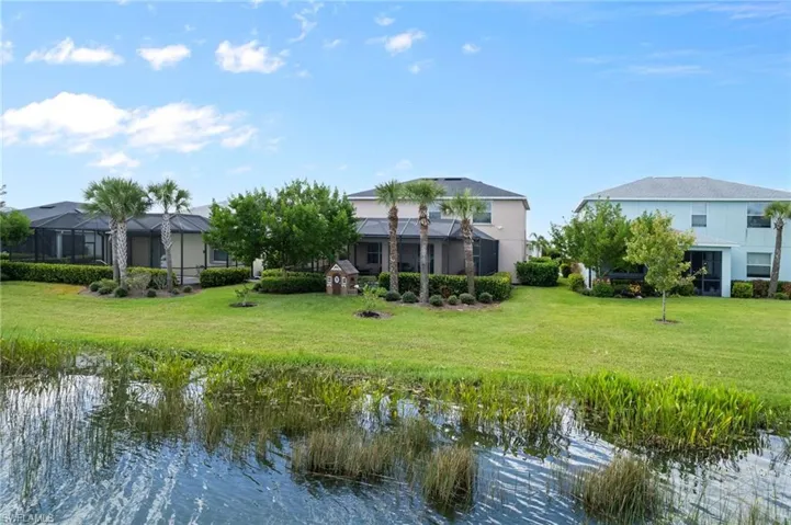 Rear view of house with a yard and a water view