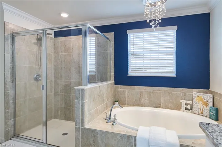 Bathroom featuring independent shower and bath and crown molding