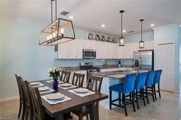 Kitchen featuring an island with sink, stainless steel appliances, sink, and white cabinetry
