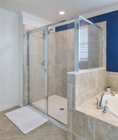 Bathroom featuring separate shower and tub, ornamental molding, and tile patterned floors