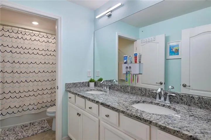 Full bathroom with vanity, toilet, shower / tub combo, and tile patterned flooring