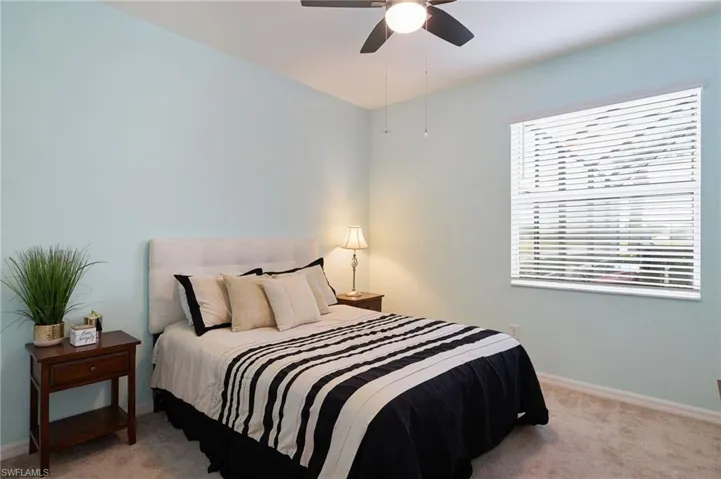 Bedroom with ceiling fan and light carpet