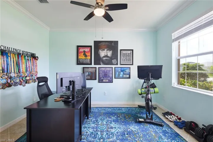 Home office featuring crown molding, ceiling fan, and tile patterned flooring