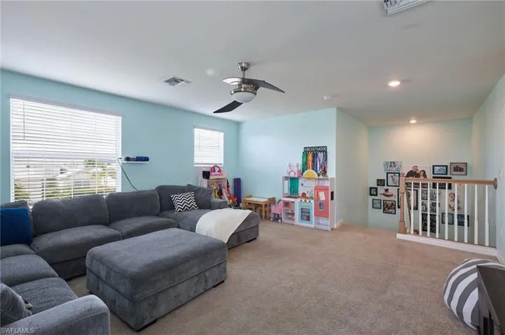 Carpeted living room with ceiling fan