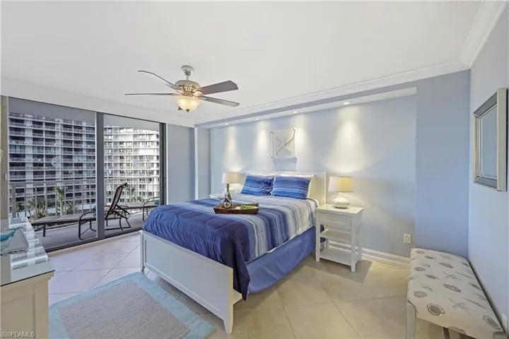 Bedroom with light tile patterned flooring, a wall of windows, access to outside, ceiling fan, and crown molding