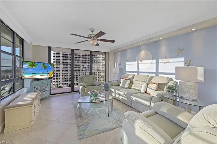 Tiled living room with crown molding, ceiling fan, and a wealth of natural light