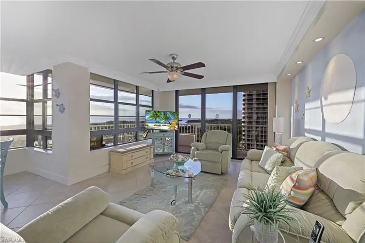 Living room with light tile patterned floors and ceiling fan