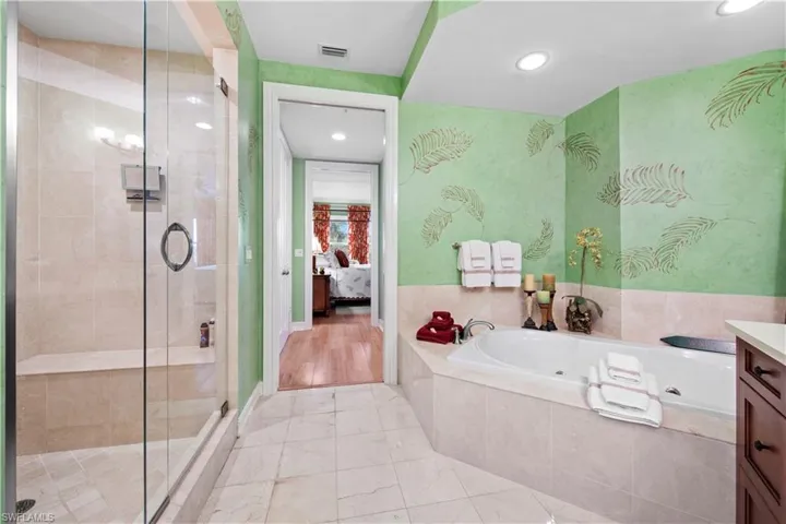 Bathroom featuring separate shower and tub and vanity