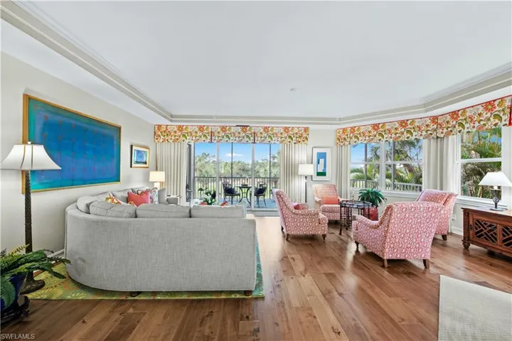 Living room featuring crown molding, plenty of natural light, and wood-type flooring