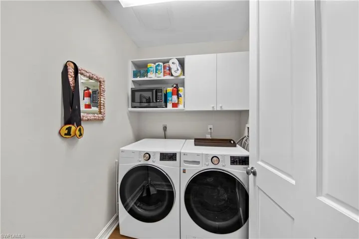 Laundry room with separate washer and dryer and cabinets
