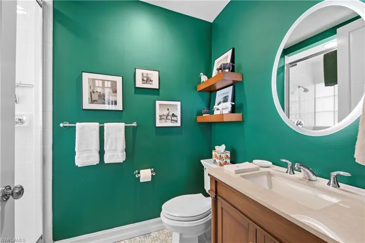 Bathroom featuring toilet, a shower with shower door, and vanity