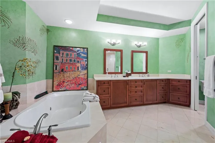 Bathroom with tiled tub and vanity