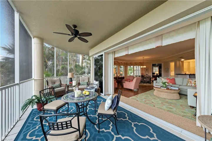 Sunroom / solarium featuring ceiling fan with notable chandelier